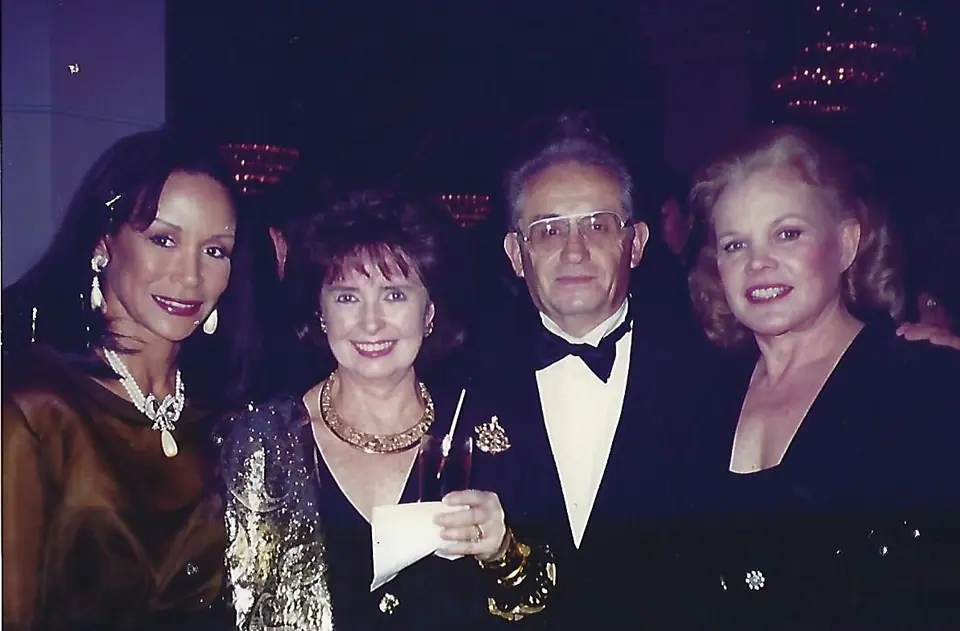 Nate Waxman in a tuxedo with Carol Baker, Margaret O'Brien and a singer at an evening event