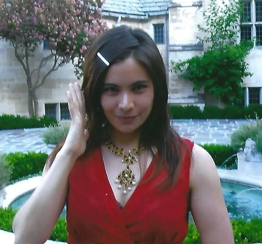 Dina Waxman in a red dress wearing a gold and garnet Swoboda statement necklace in a garden