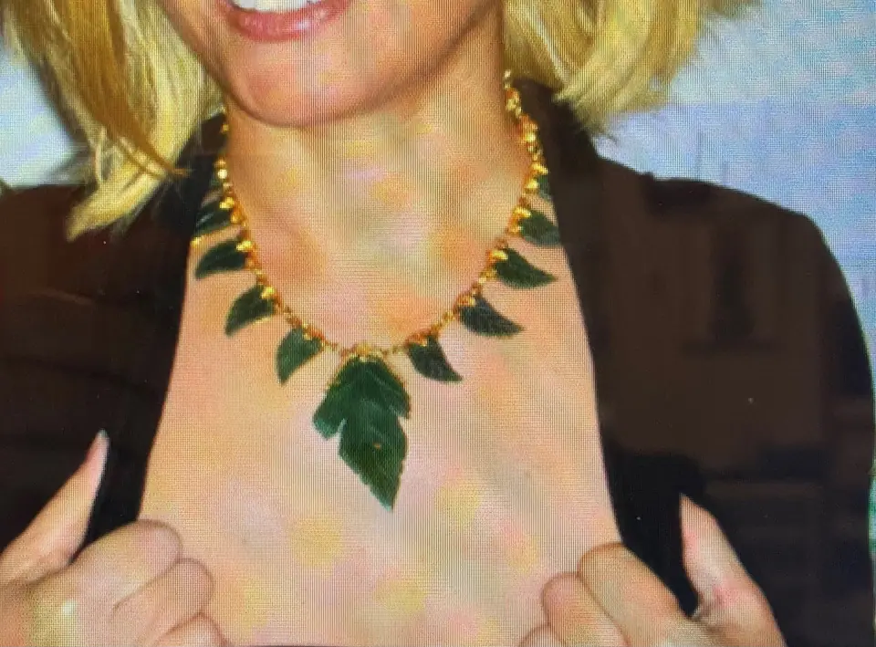 Close-up of a gold Swoboda necklace with carved green jade leaves