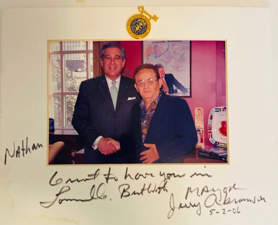 Framed photo of Nate Waxman shaking hands with Louisville Mayor Jerry Abramson, signed and mounted with a key to the city