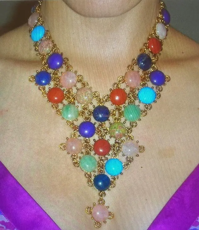 Close-up of a Swoboda bib necklace set with round cabochons of lapis, coral, jade, rose quartz and turquoise
